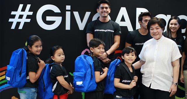 Convergys Philippines Country Manager Ivic Mueco (rightmost) is joined by the young cast members of the Give A Bag of Hope video as they show off the actual bags, which will be given out to students of several Filipino elementary schools nationwide.