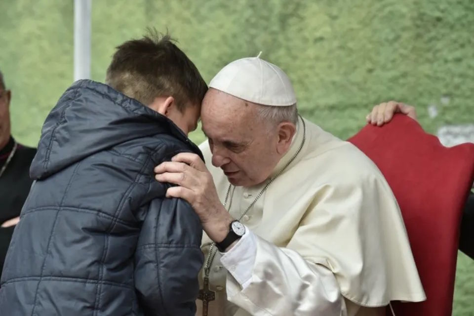 Pope Francis listens to a boy