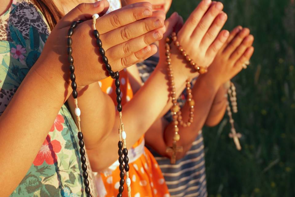 Children praying the rosary stock