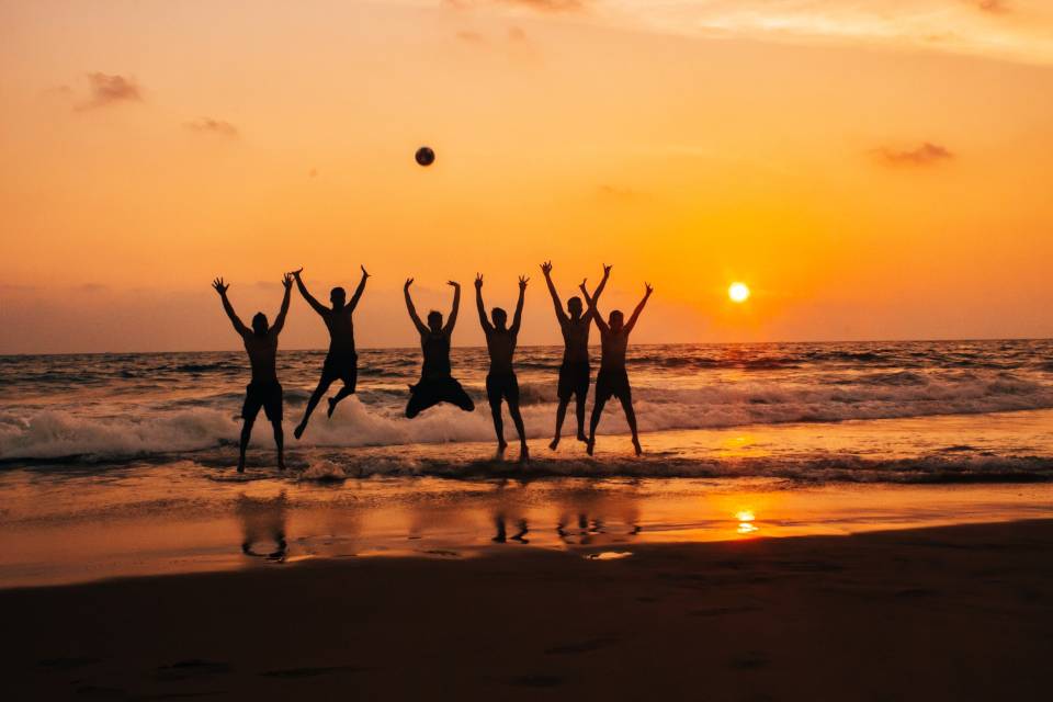 stock people jumping carefree sunset beach silhouette Daniel Joshua on unsplash