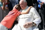 Pope Francis embraces a child at a Wednesday General Audience