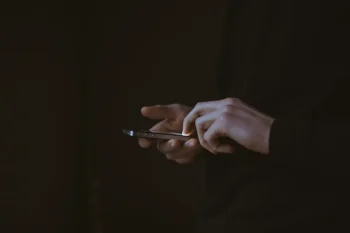 stock photo of a man holding smartphone cellphone by Gilles Lambert on unsplash