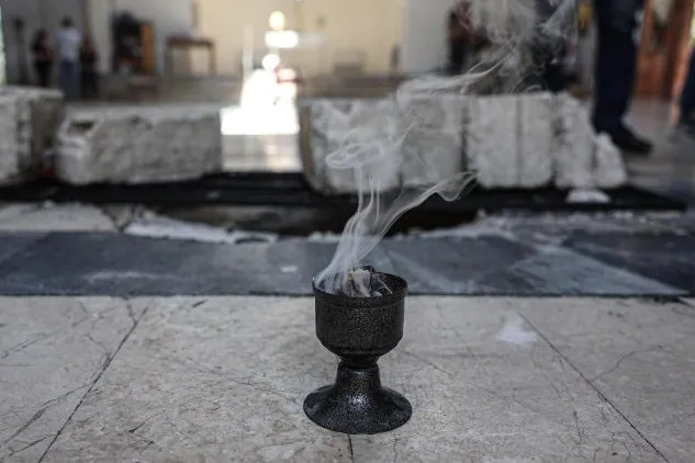 Incense burns during a vigil for the victims at Mar Elias Church