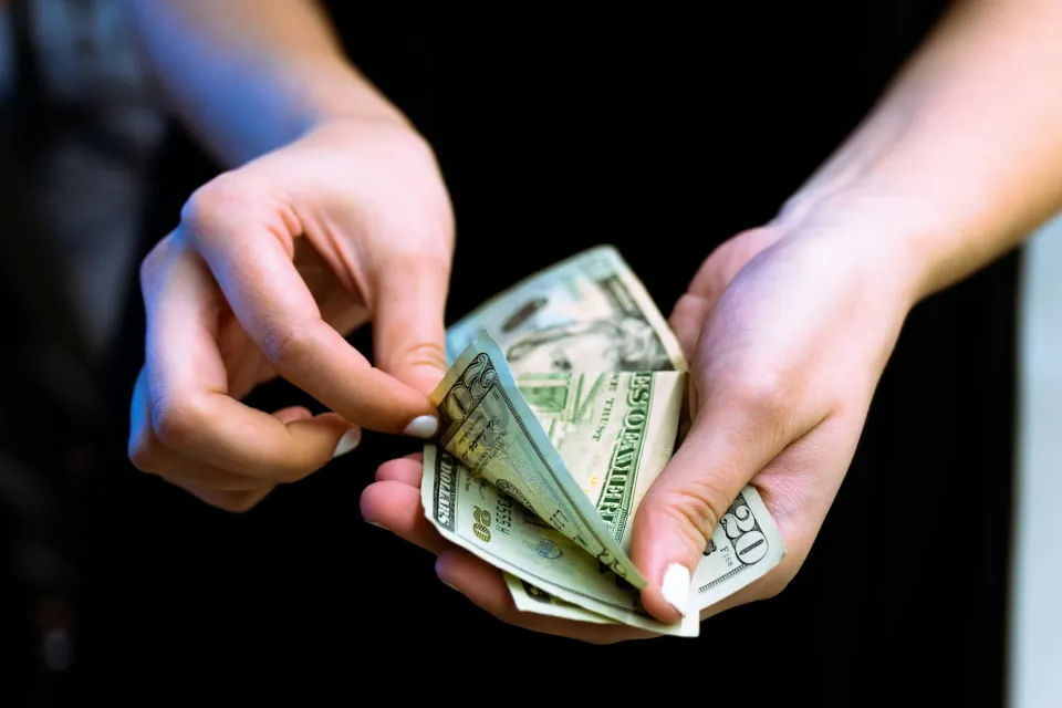 stock photo of person holding counting money by Igal Ness on Unsplash