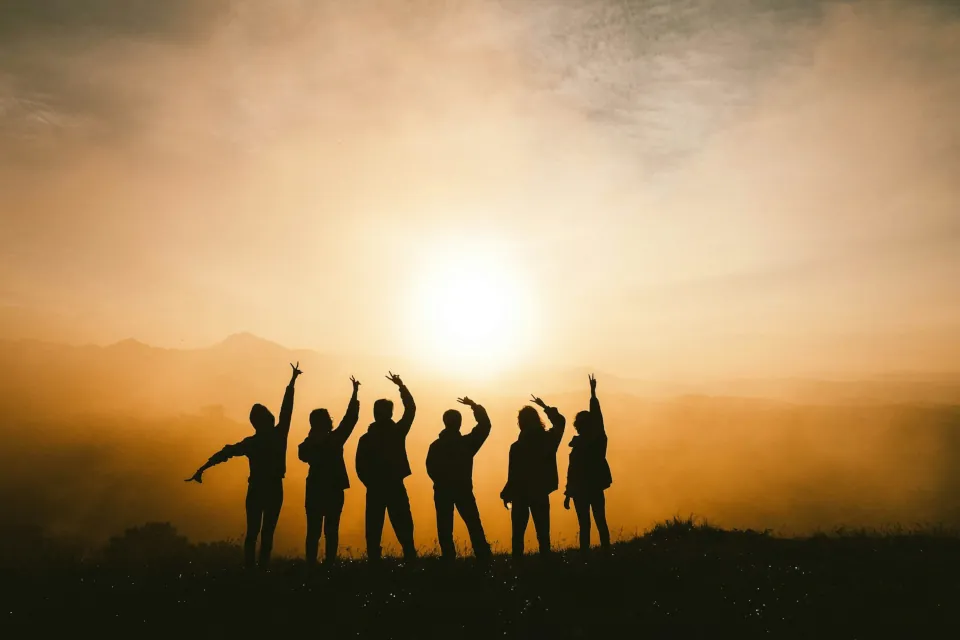 stock photo silhouette of youth young people on top of mountain by Chang Duong on Unsplash